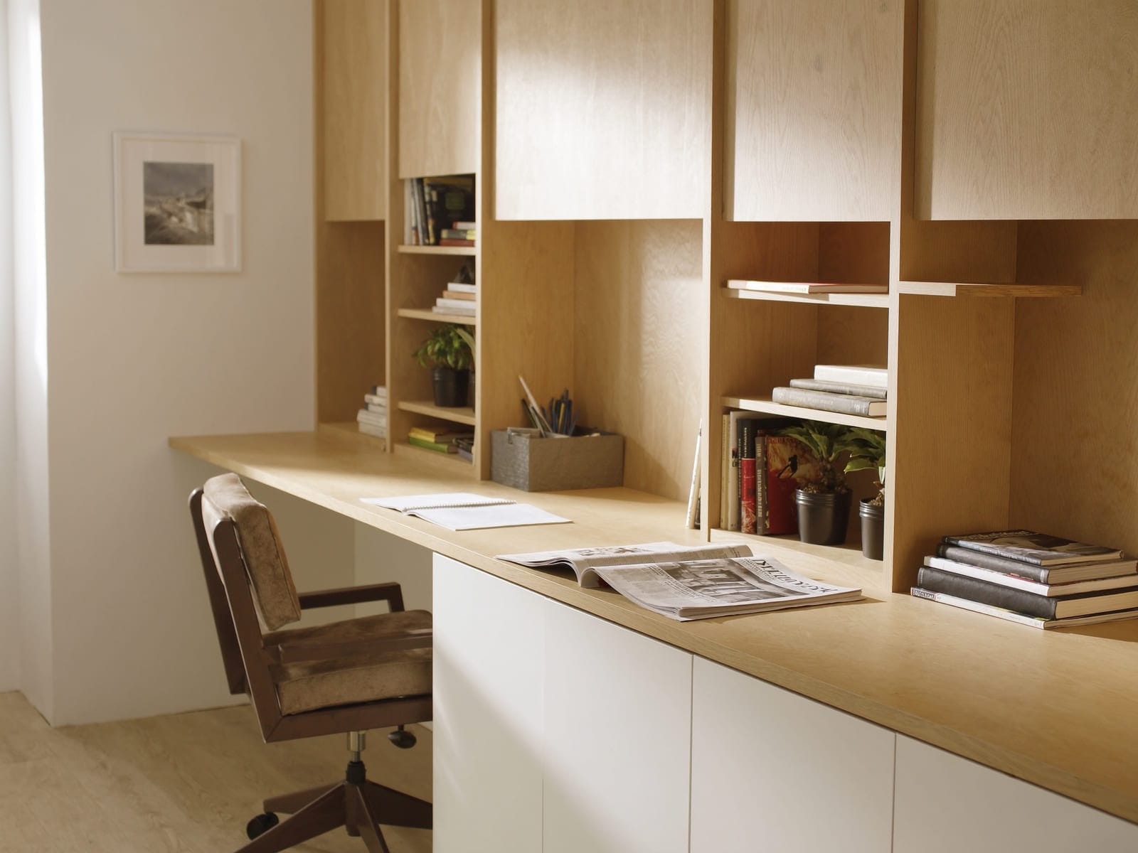 A built-in home office with a long desk top in oak woodgrain laminate, matching floor to ceiling shelving and closed cupboards in white melamine. Illustrative concept visual, not a real photograph.